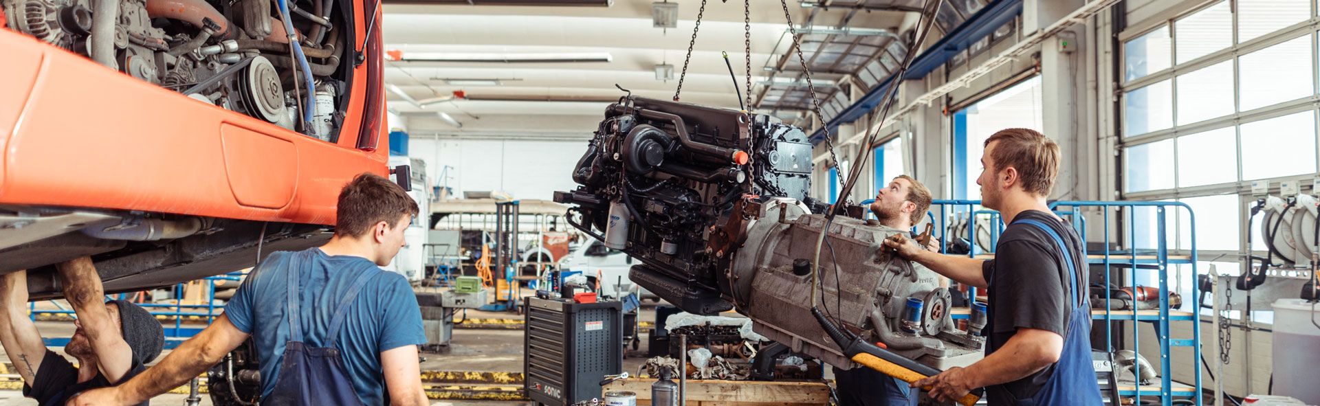 Mitarbeiter von Motoren Bauer beim Reparieren eines Busses mit Motor